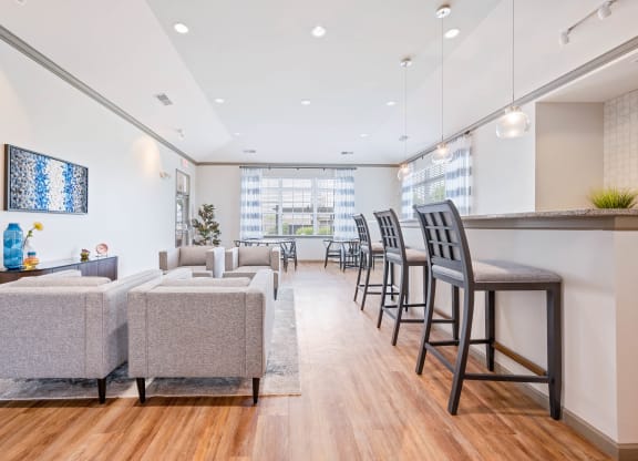 a seating area with couches chairs and a bar