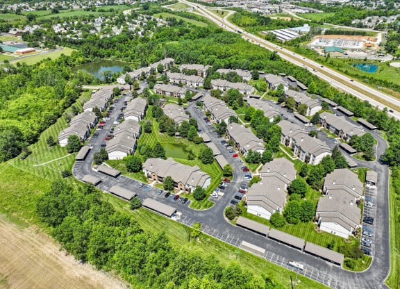 an aerial view of a suburban neighbourhood with cars parked in a parking lot