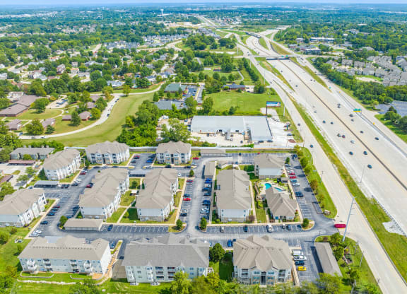 an aerial view of a neighborhood of houses with cars parked on the side of the road