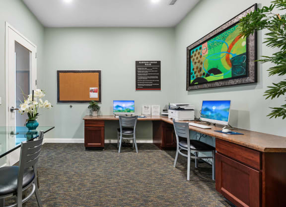 a office with two computers and a desk with chairs