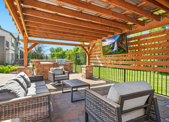 a covered patio with furniture and a grill