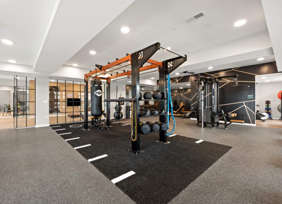 a gym with weights and other exercise equipment in a building with glass doors