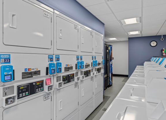 a row of gray lockers in a room with a clock on the wall