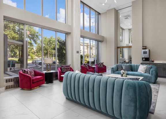 a living room filled with furniture and large windows