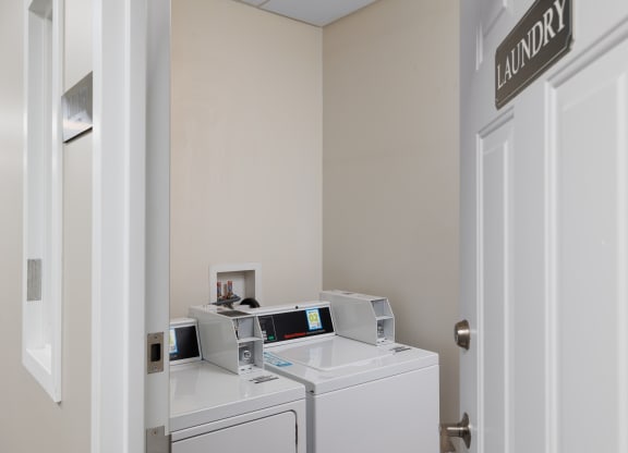a laundry room with two washers and two washing machines