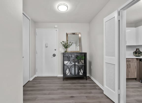 a hallway with white walls and a white door