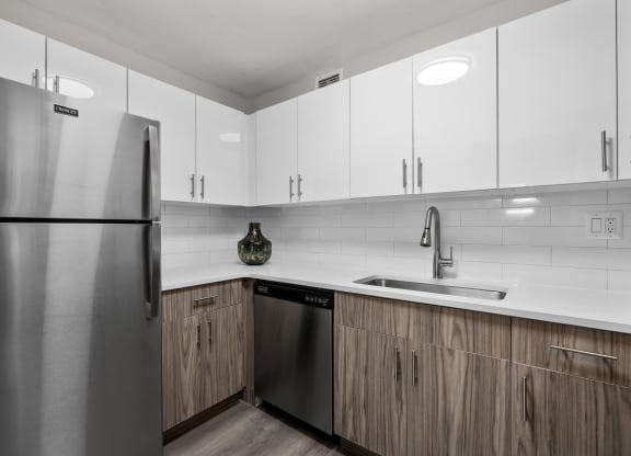a kitchen with white cabinets and a stainless steel dishwasher