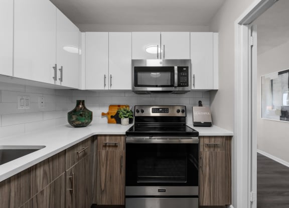 a kitchen with white cabinets and a black stove top oven