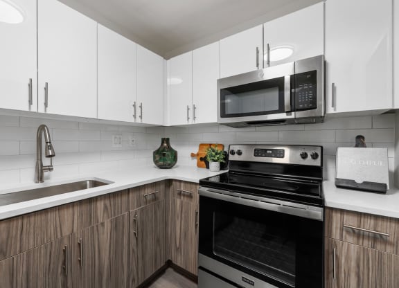 a kitchen with white cabinets and black appliances