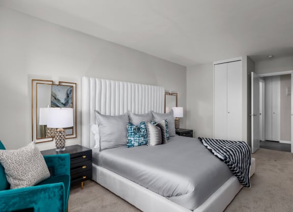 a bedroom with a bed and a chair in a room