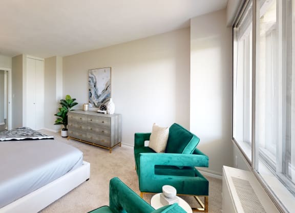 a bedroom with a bed and a dresser in front of a window