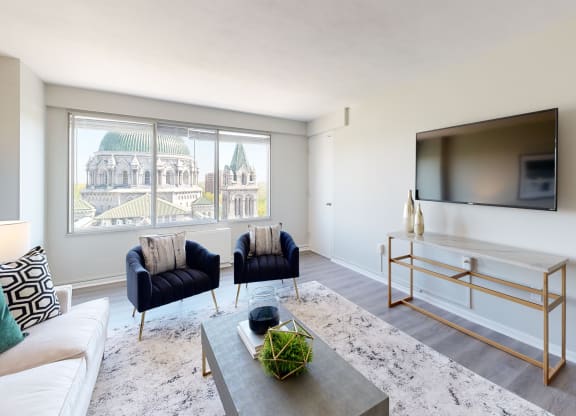 a living room with a large window and a tv on the wall