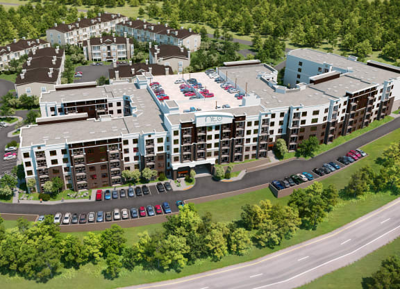 an aerial view of a large apartment complex with cars parked in front of it