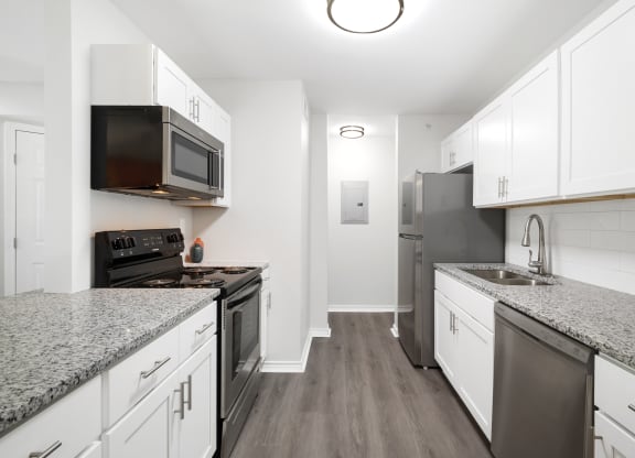 a kitchen with white cabinets and stainless steel appliances and granite counter tops