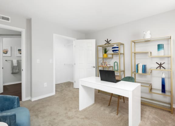 a living room with a white desk with a laptop on it