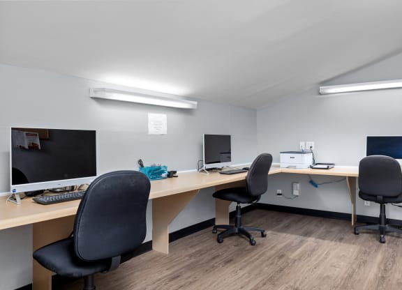 two computers and two chairs in an office
