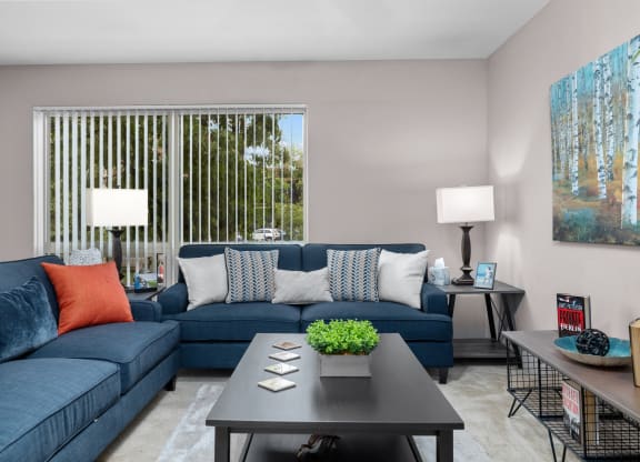 a living room with blue couches and a coffee table