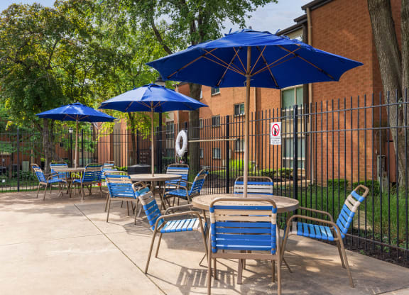 a patio with tables and chairs and umbrellas