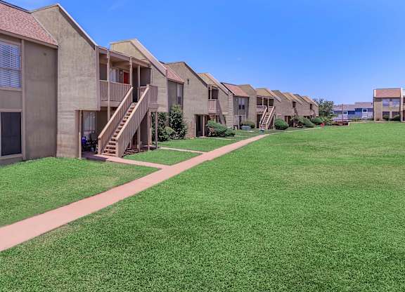 a row of houses with stairs and green grass