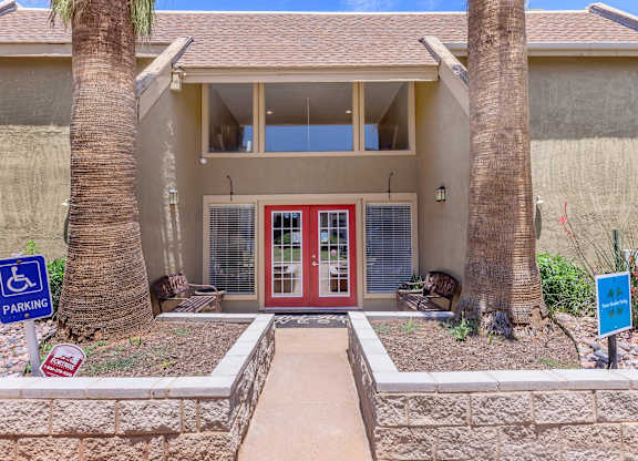 a house with a red door and two palm trees