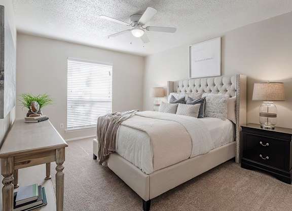 a bedroom with a bed and a ceiling fan