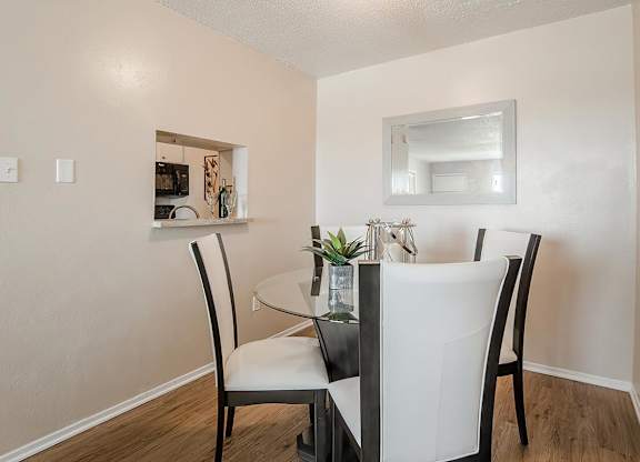 a dining room with a glass table and chairs