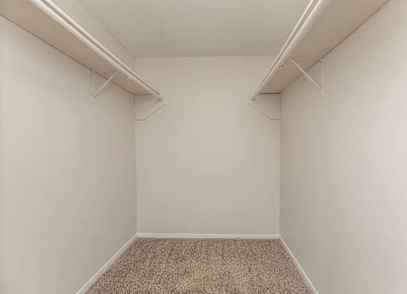 an empty room with white walls and two shelves on the wall