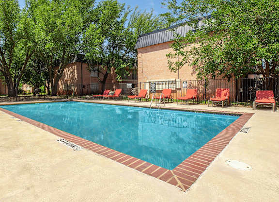 A rectangular pool with red tile border and a concrete floor.
