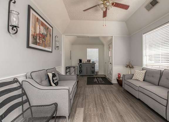 a living room with two couches and a ceiling fan