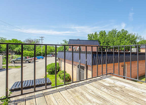a balcony with a wooden deck and a brick building