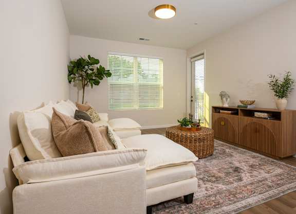 A living room with a white sofa and a wooden cabinet.