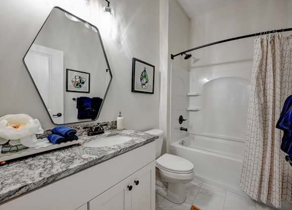 A bathroom with a marble countertop and a white toilet.