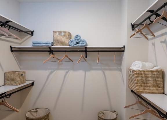 A laundry room with a white wall and a wooden floor.