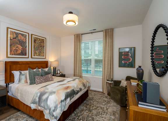 A bedroom with a large bed and a mirror on the wall.
