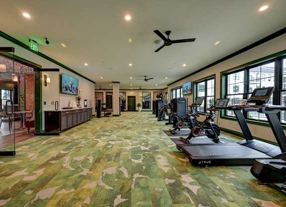 A gym with a camouflage carpet and exercise equipment.