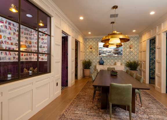 A dining room with a table set for six.