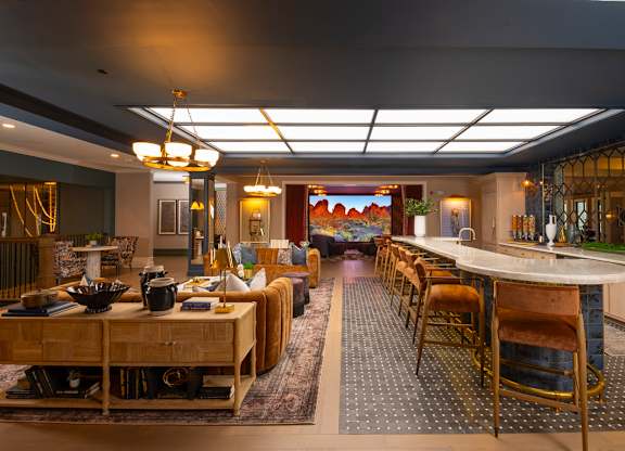 A modern dining room with a long table set for a meal.