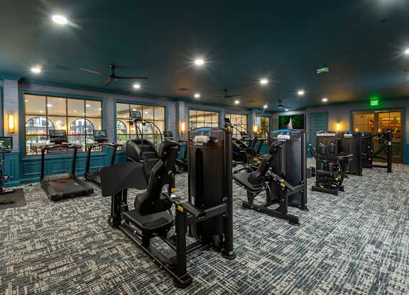A gym with a variety of equipment including treadmills, stationary bikes, and weight machines.