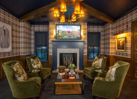 A cozy room with a fireplace and green chairs.