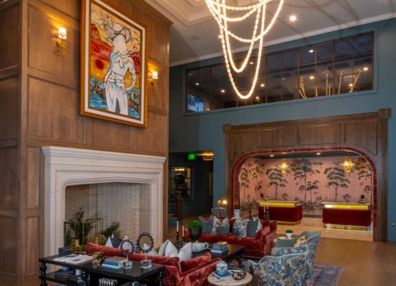 A living room with a fireplace and a painting on the wall.