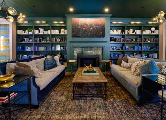 A living room with a fireplace and a bookshelf.