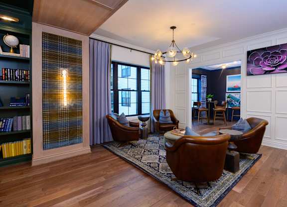 A living room with a chandelier, a couch, a chair, and a rug.