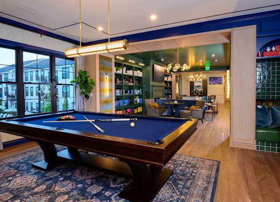 A pool table in a room with a view of the street outside.