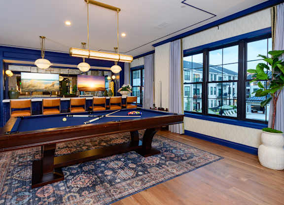 A pool table is in the middle of a room with a blue carpet.