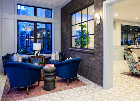 Sitting area with blue velvet chairs and large windows at Fairmont Apartments, Westerville, 43081