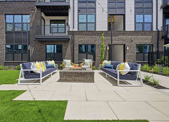 A patio with two chairs and a table in front of a building.