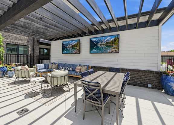 A patio with a table and chairs under a roof.
