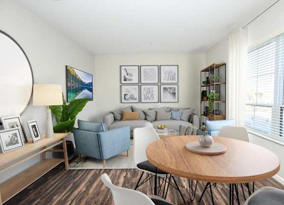 A living room with a grey couch, a wooden table, and a painting on the wall.