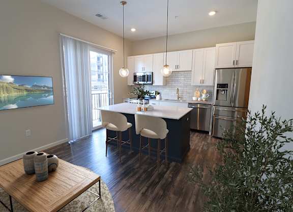 A modern kitchen with a dining table and chairs.