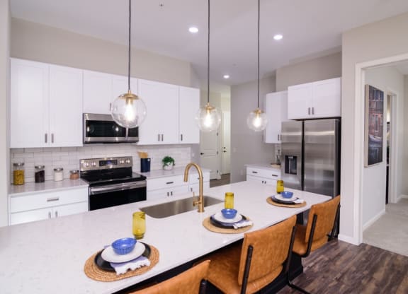 a kitchen with white cabinets and a large island with a white countertop at Essex, Columbus, OH